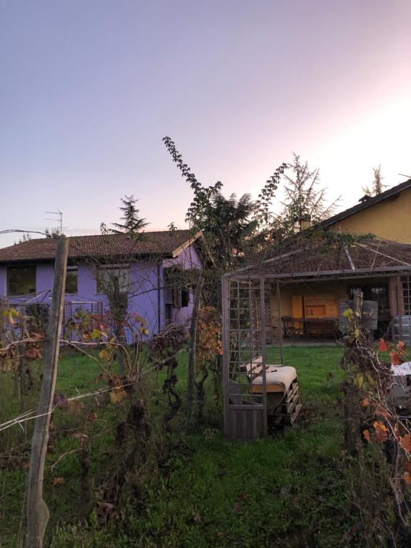 un patio con una casa y una valla en Cascina La Maddalena Bed & Wine, en Rocca Grimalda