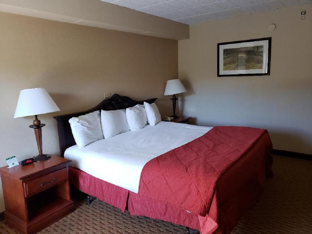 a hotel room with a large bed and two lamps at The Chateau Resort in Tannersville