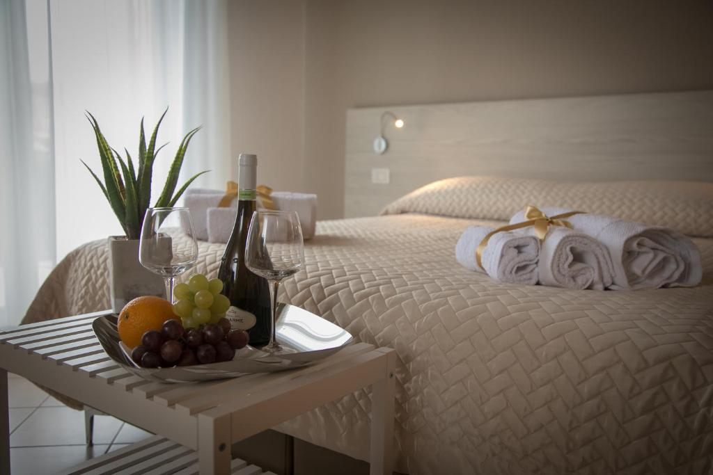 1 dormitorio con 1 cama y bandeja de fruta y copas de vino en Musmelia Rooms - Affittacamere, en Mussomeli