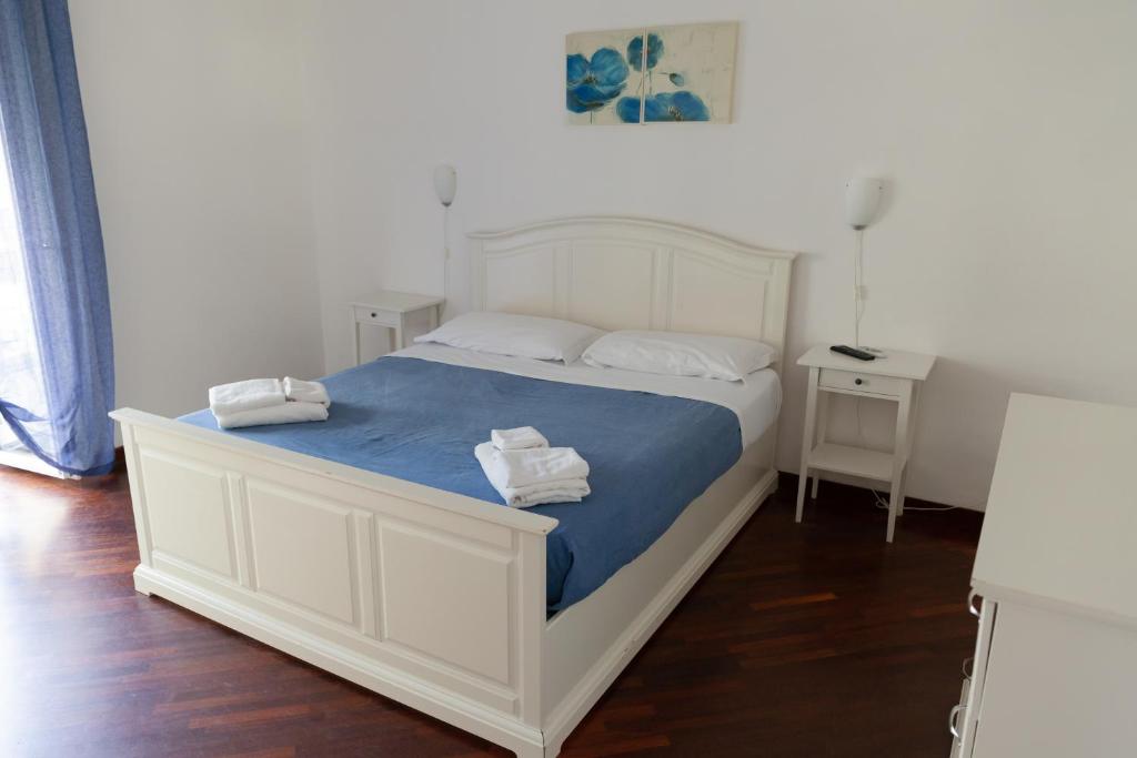 ein Schlafzimmer mit einem weißen Bett und Handtüchern darauf in der Unterkunft Appartamento Velia in Salerno