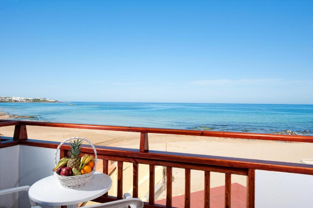 スタリスにあるVlachakis Hotelのビーチを見渡すバルコニーのテーブルにフルーツバスケットを用意しています。