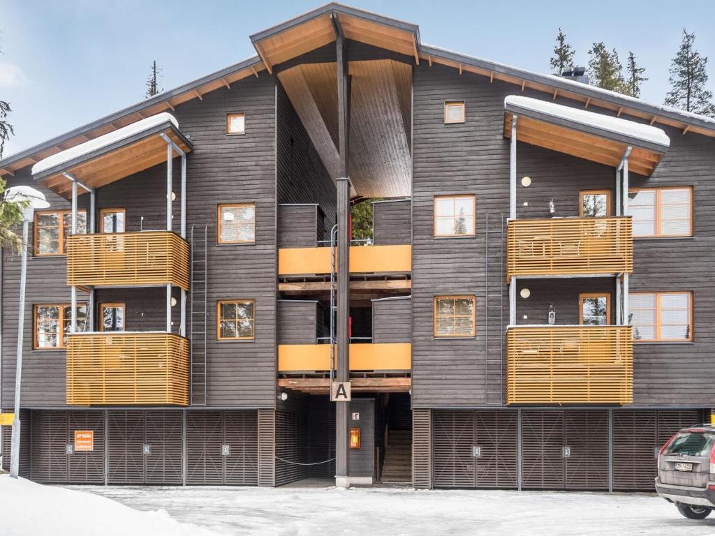 a building with wooden balconies on the side of it at Holiday Home Karhunvartijan linna a1 by Interhome in Ruka