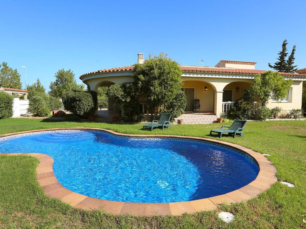 a swimming pool in the yard of a house at Holiday Home El Jardi by Interhome in Riumar