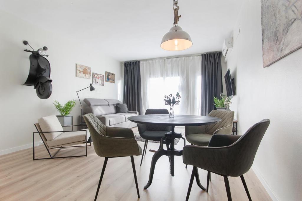 comedor y sala de estar con mesa y sillas en Tendency Apartments 8, en Barcelona