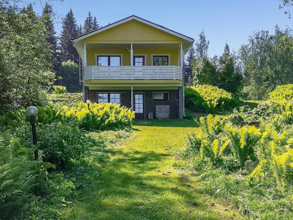 a yellow house in the middle of a garden at Holiday Home Villa-lyydia by Interhome in Niemikylät