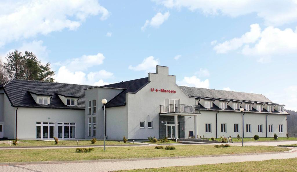 a large white building with a black roof at Zajazd u Marcela in Gollnow