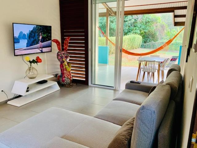 sala de estar con sofá y TV en L OREE DU BOIS, en Cayenne