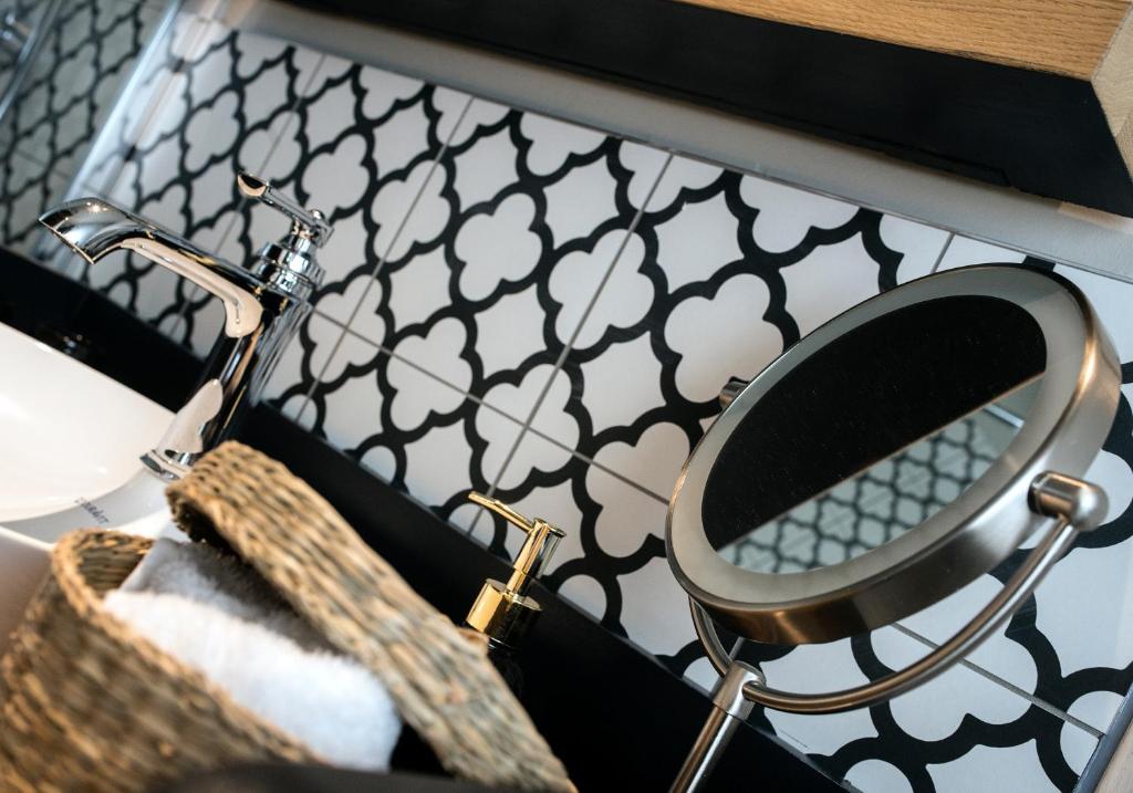 a mirror on a shelf with a basket and a sink at Chez Gisèle Gîte de prestige à Samer in Samer