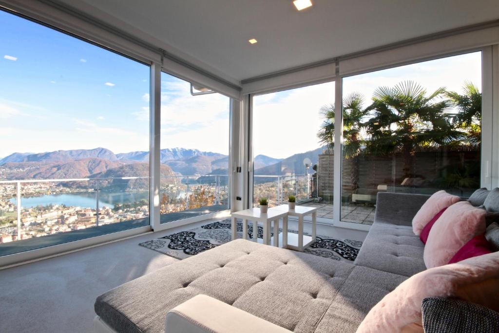 un soggiorno con divano e ampie finestre di Loft Mirage a Cadegliano Viconago