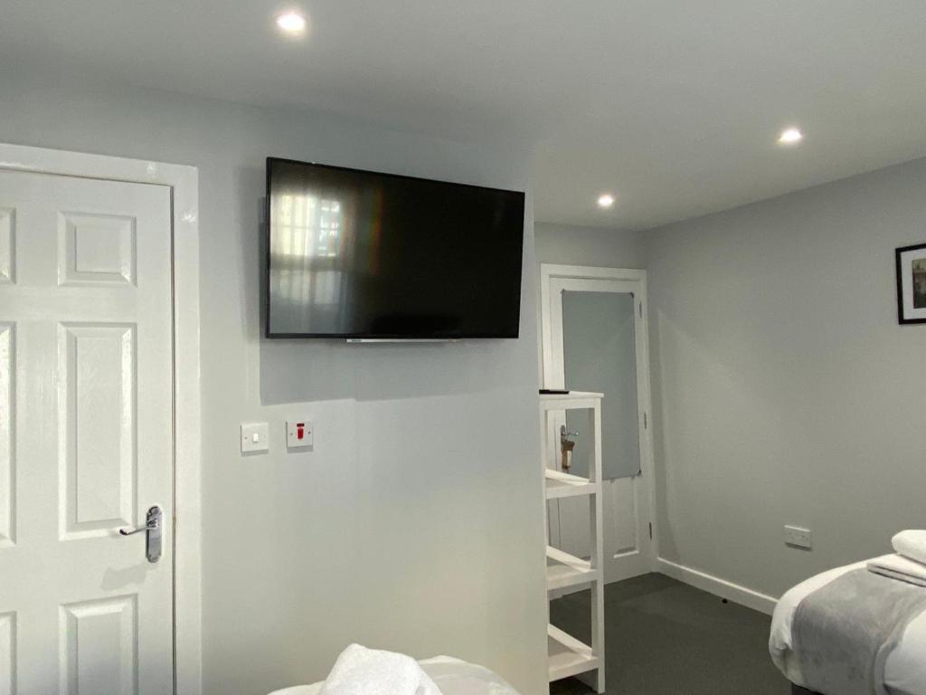 um quarto com uma televisão de ecrã plano na parede em Brownlows Inn Rooms formerly Riley's Rooms em Liverpool