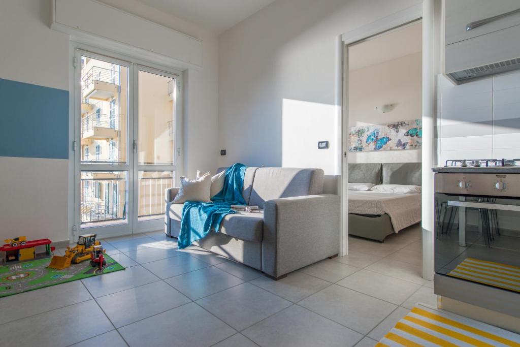 a living room with a chair and a bed at Babyaccommodation Family Experience in Pietra Ligure