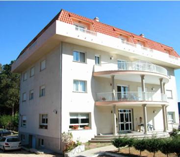 a large white building with an orange roof at Hotel Ria Toxa in Revolta