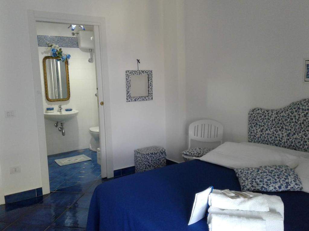 a bedroom with a blue bed and a sink at Casa Blu Cobalto in Maiori