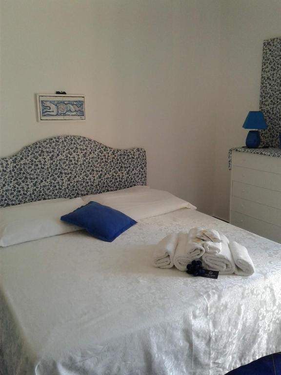 a bed with white sheets and blue pillows on it at Casa Blu Cobalto in Maiori