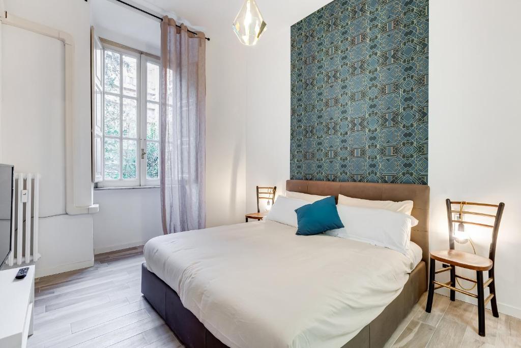 sypialnia z dużym łóżkiem i niebieską ścianą w obiekcie BDC - Termini Sun Apartment w Rzymie