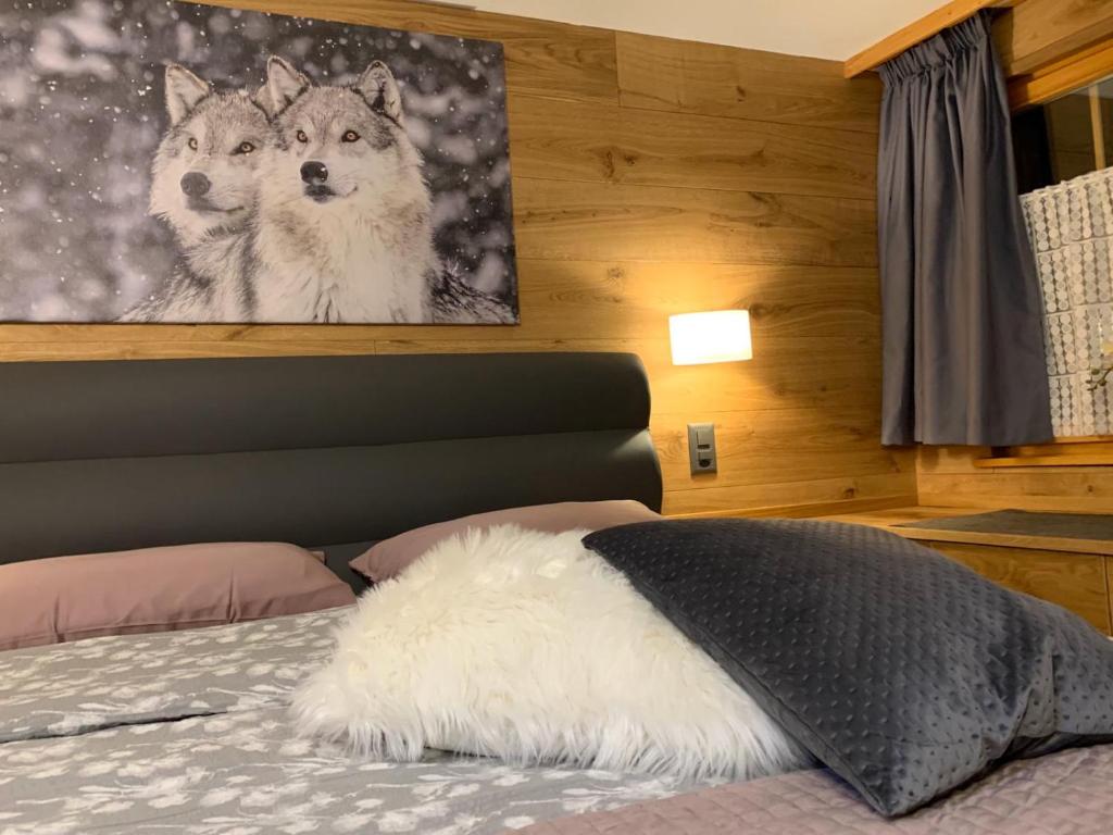 a white dog laying on a bed in a bedroom at Kirchplatz Apartment Lupus in Zermatt