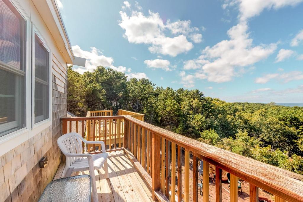 a deck with a chair and a view of the ocean at Bayview in Truro