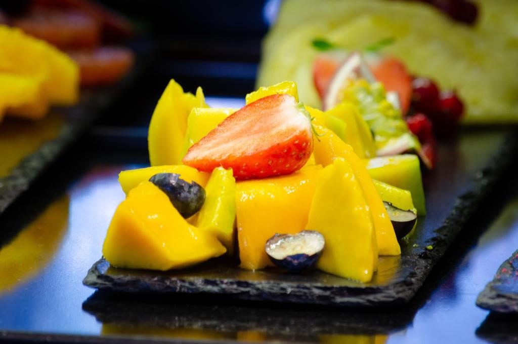 A close-up of sliced tropical fruit arranged on black serving plates.