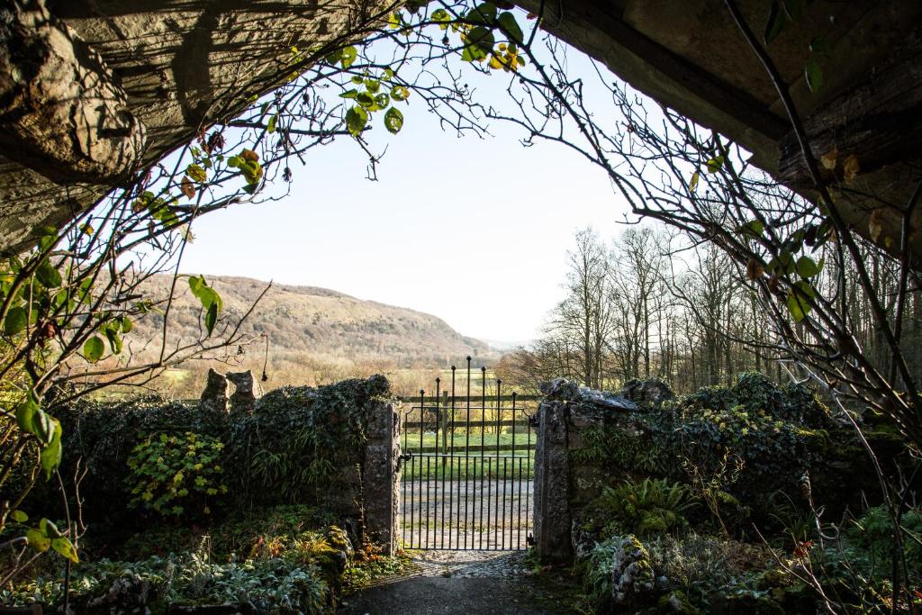 una puerta en un jardín con vistas a un campo en Witherslack Hall Farmhouse en Grange Over Sands