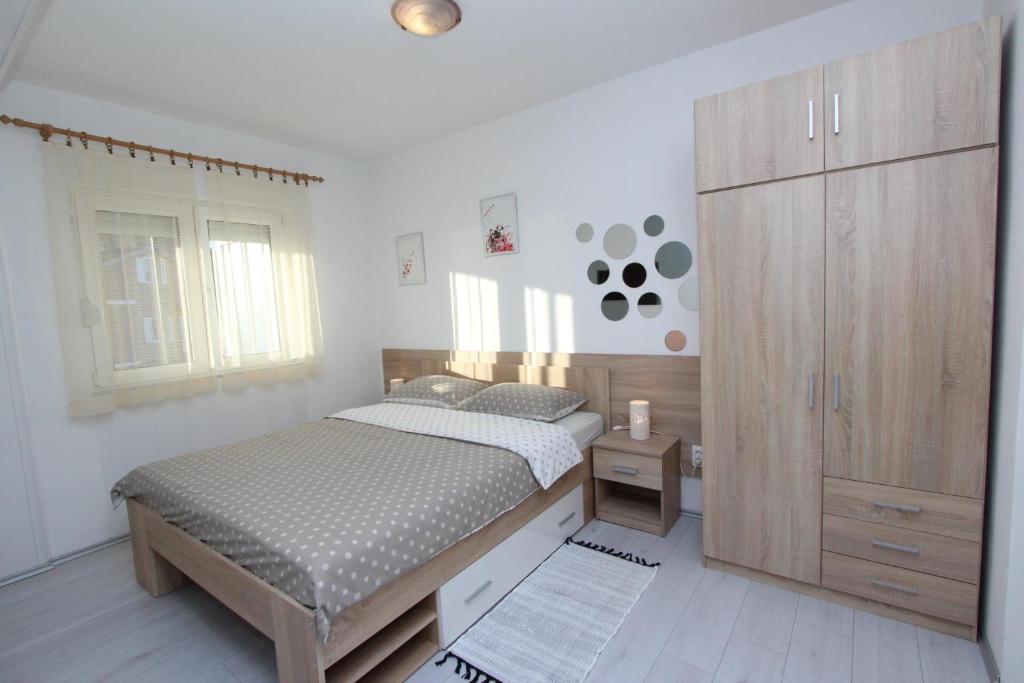 een slaapkamer met een bed en een grote houten kast bij Apartments and Room Eva in Rovinj