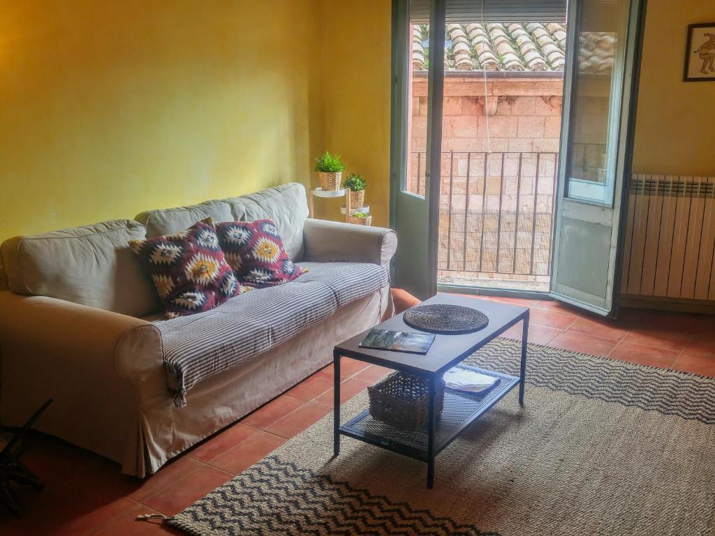 uma sala de estar com um sofá e uma mesa em Apartamentos Saltarel·lo em Besalú