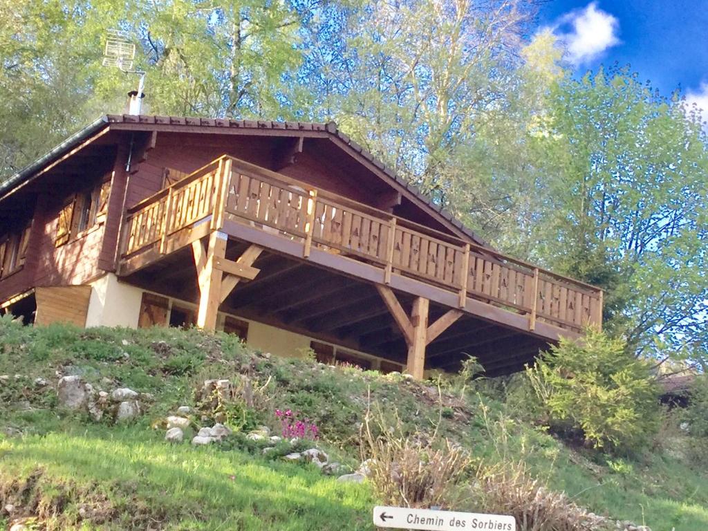 a log cabin with a deck on a hill at Chalet le val’tin in Ventron