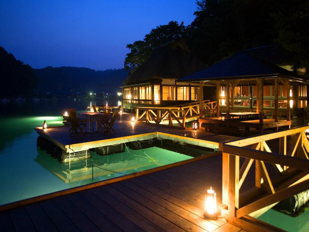 a house with a pool on a deck at night at Noto Hyakurakusou in Ogi