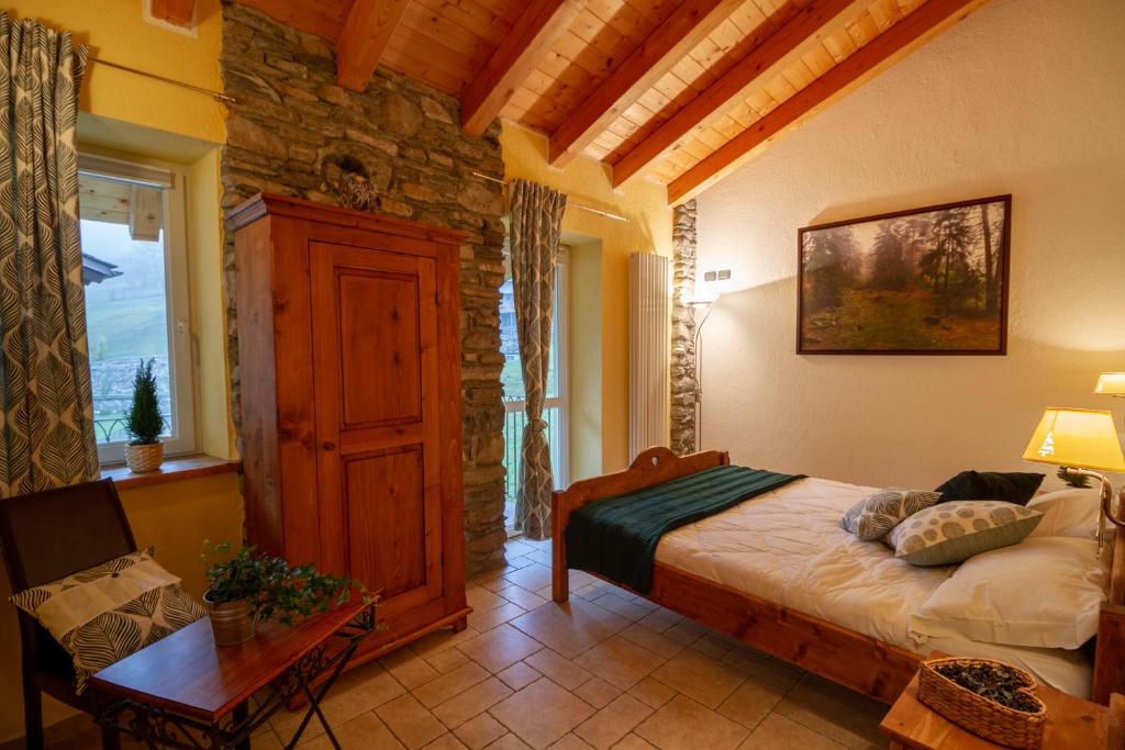 - une chambre avec un lit et un mur en pierre dans l'établissement La Grange, à Aymavilles