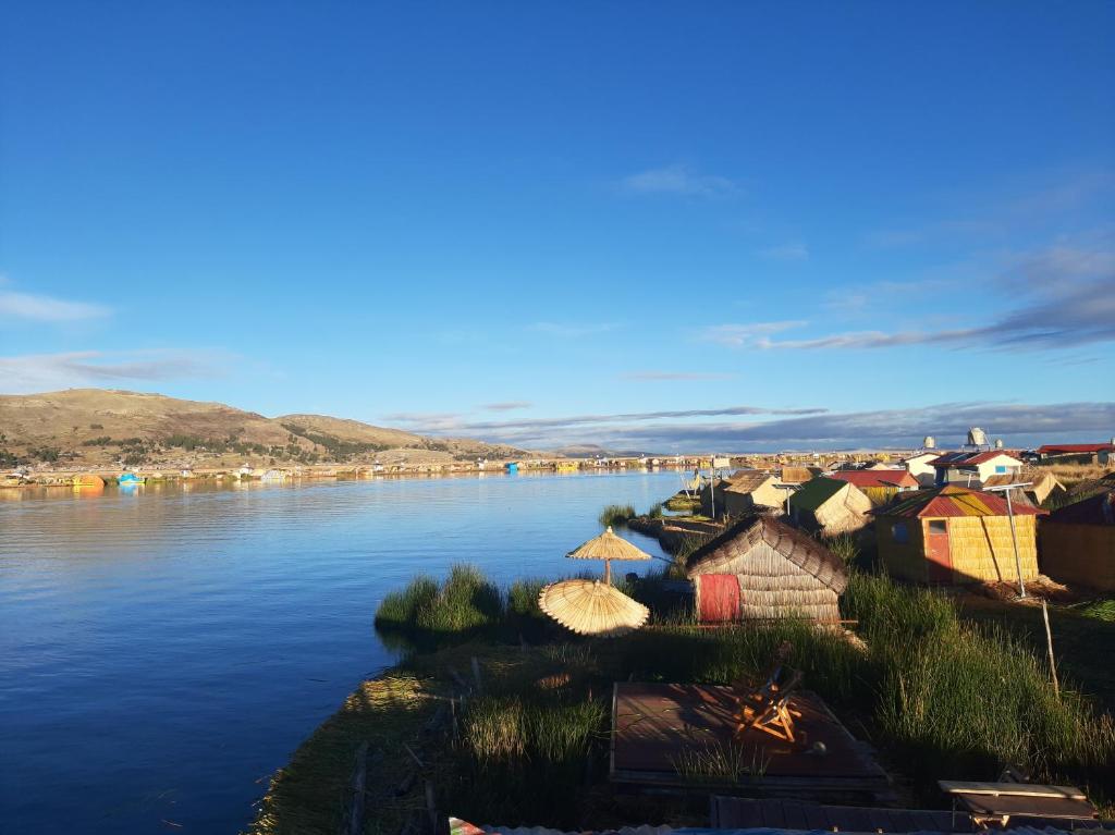 uma vista para um rio com casas na costa em Quechua lodge Titicaca em Puno