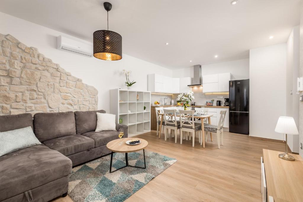 sala de estar y cocina con sofá y mesa en New Cosy Apartment Ivan, en Opatija