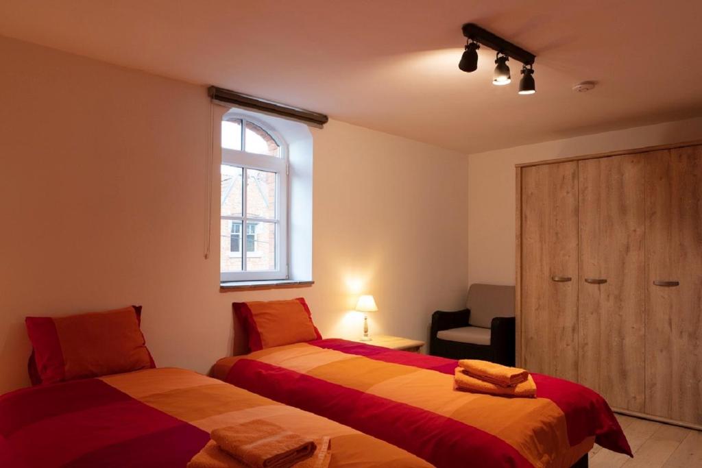 1 Schlafzimmer mit 2 Betten und einem Fenster in der Unterkunft Plumer House in Ypern