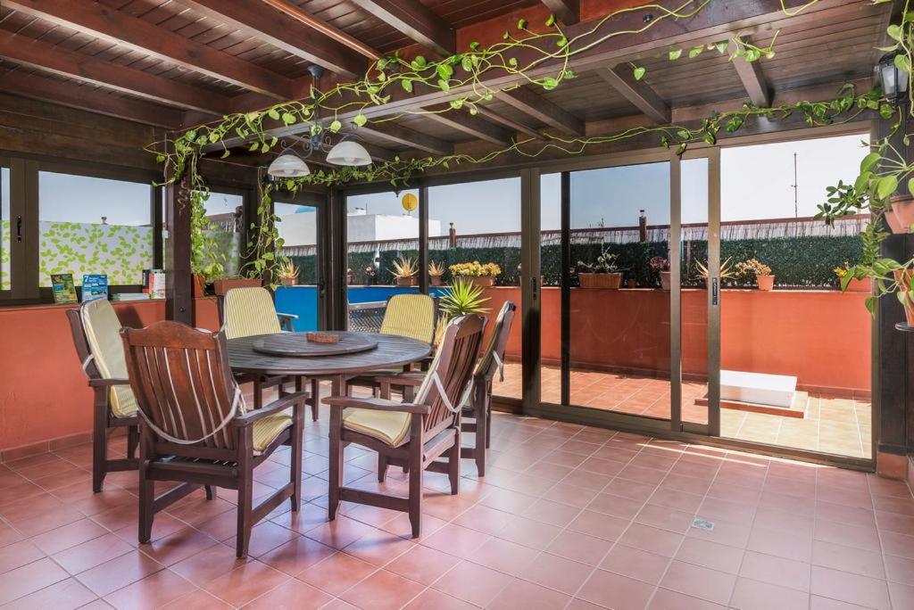 un patio con mesa de madera y sillas en casa orymar en El Cotillo