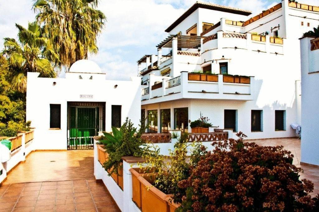 un edificio blanco con plantas en un balcón en Bahía Santa Cruz, en Almuñécar