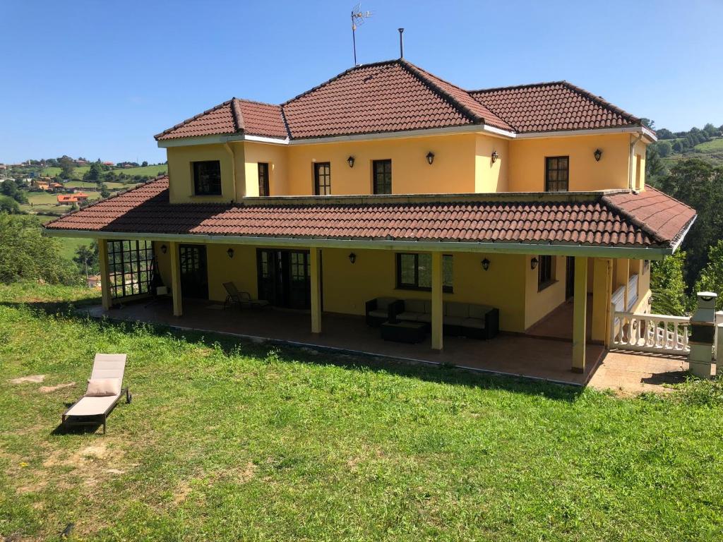 a large yellow house with a roof at La casina de Kiko in Gijón