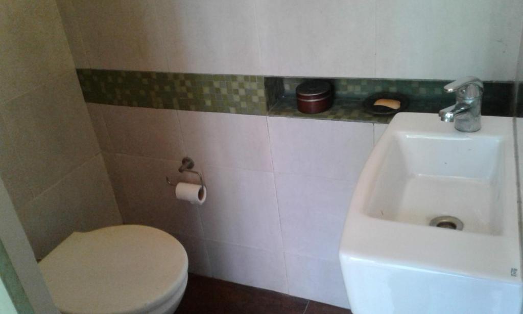 y baño con aseo blanco y lavamanos. en Experiencia Abasto en Buenos Aires