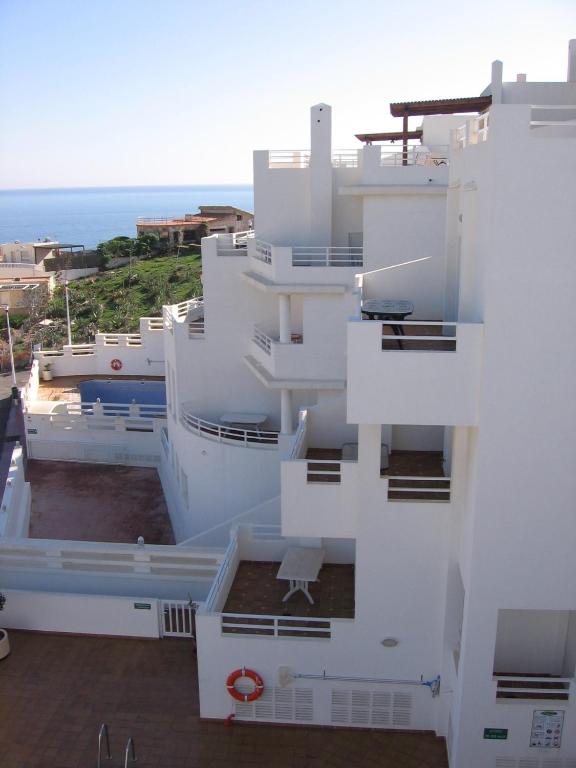 a white building with the ocean in the background at Apartahotel Vistamar San José in San José
