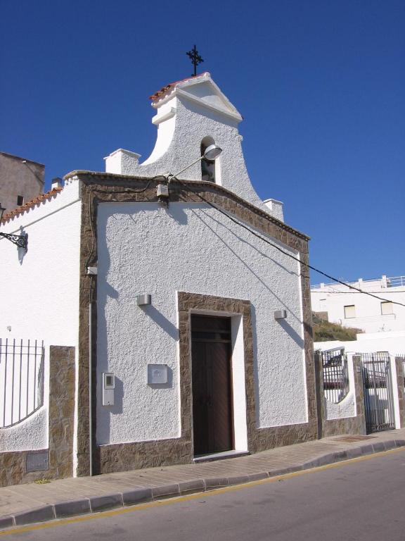 a white church with a cross on top of it at Apartahotel Vistamar San José in San José