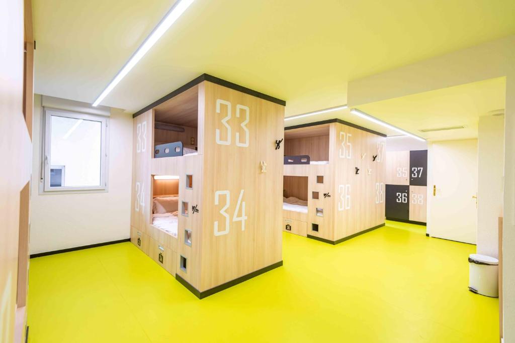 a row of lockers in a room with yellow floors at Hostel Le Hüb Grenoble in Grenoble