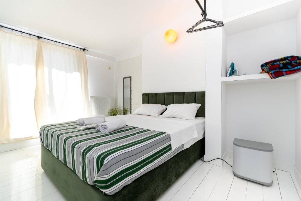 ein Schlafzimmer mit einem Bett mit einer gestreiften Decke in der Unterkunft Wehost Apartment With Huge Terrace in Tbilisi City