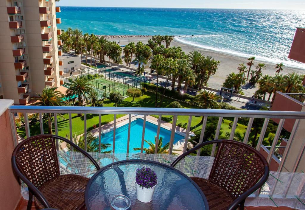 balcón con mesa y sillas y vistas a la playa en Las Góndolas Apartamento Sunny, en Almuñécar