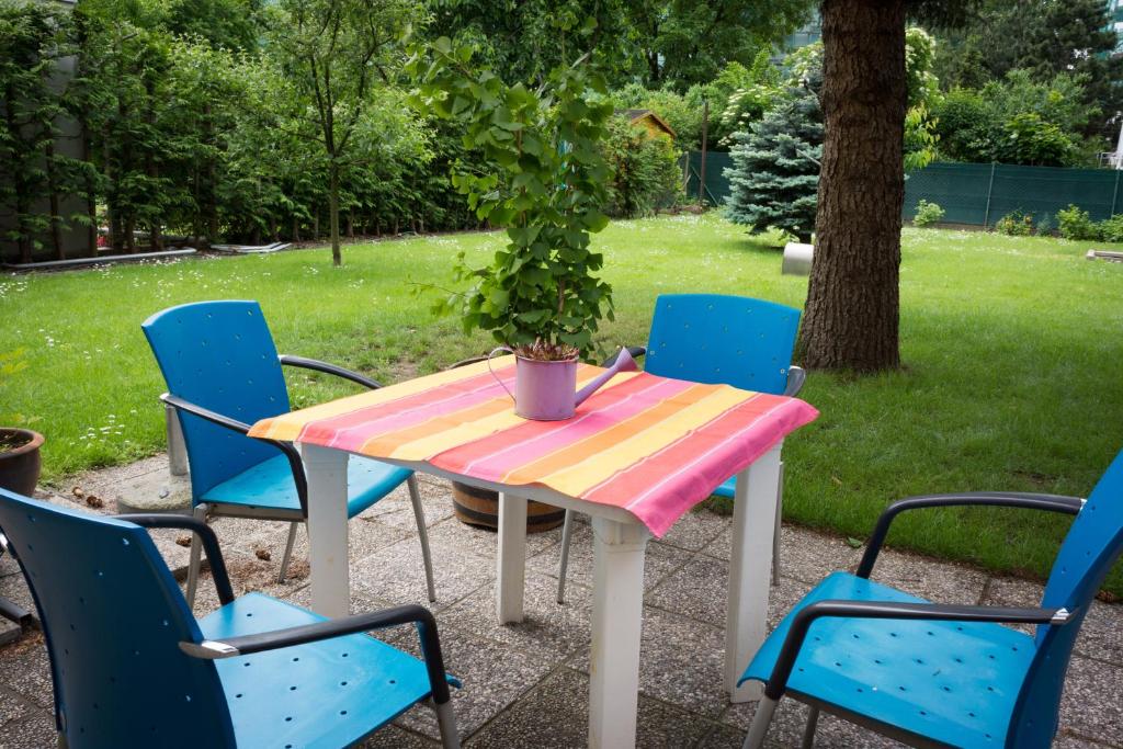 a table and chairs with a potted plant on it at Garden Apartment Donau-City (P&R) in Vienna