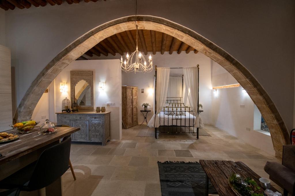 a large room with an archway and a bedroom at Apanemia Inn Studio in Lofou
