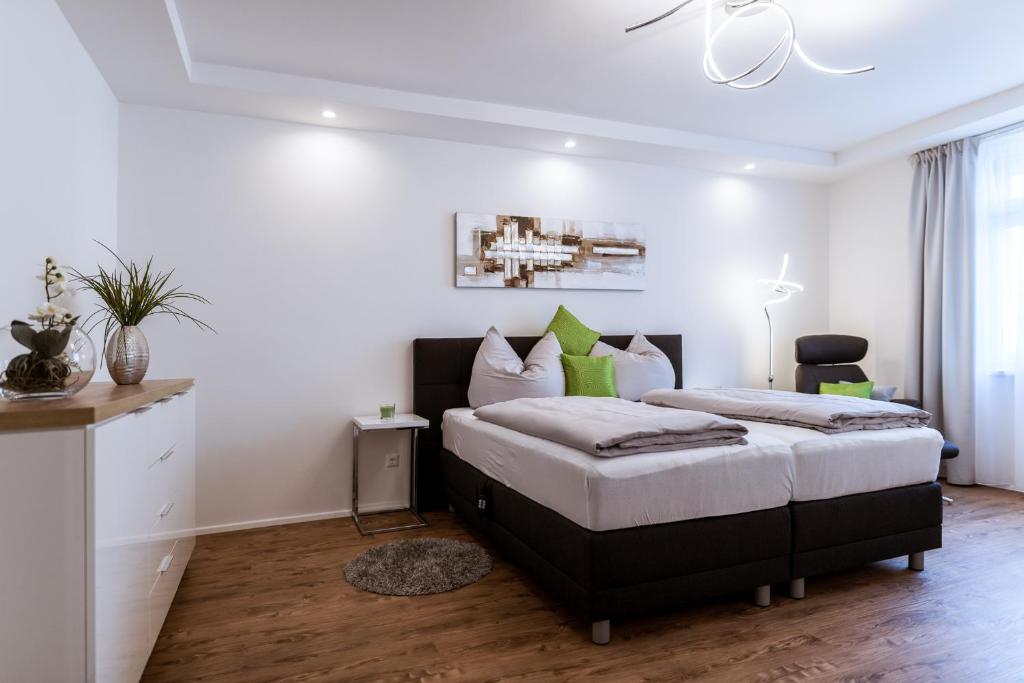 - une chambre avec un lit aux murs blancs et du parquet dans l'établissement MH Living - 11 - Modern Living Dream in Center, à Graz