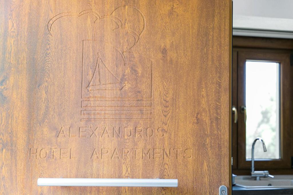 a wooden door with a sign that reads alamedaolis hotel appliance at Alexandros Hotel Apartments in Vourvourou
