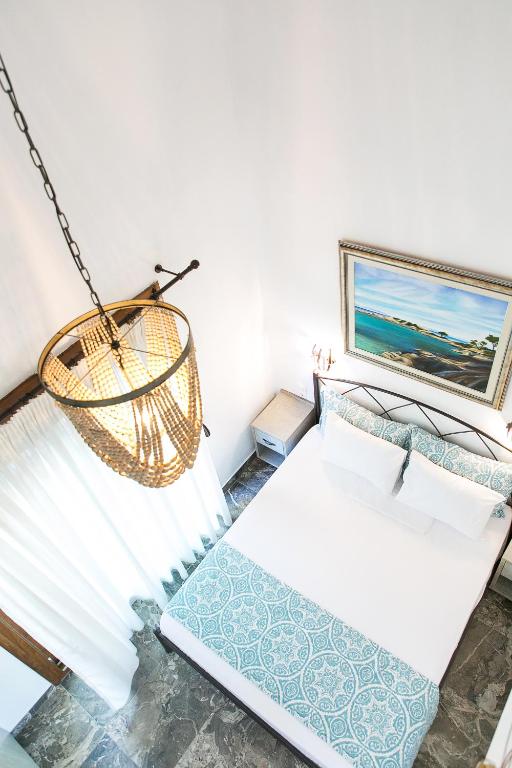 a bedroom with a bed and a hanging basket at Alexandros Hotel Apartments in Vourvourou