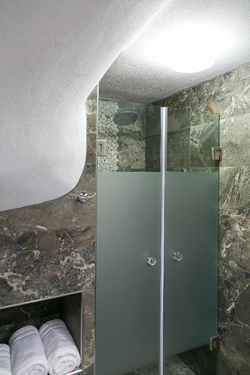 a shower with a glass door in a bathroom at Alexandros Hotel Apartments in Vourvourou