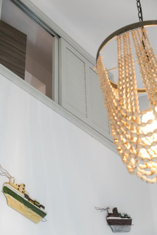 a chandelier hanging over a window with a toy ship at Alexandros Hotel Apartments in Vourvourou
