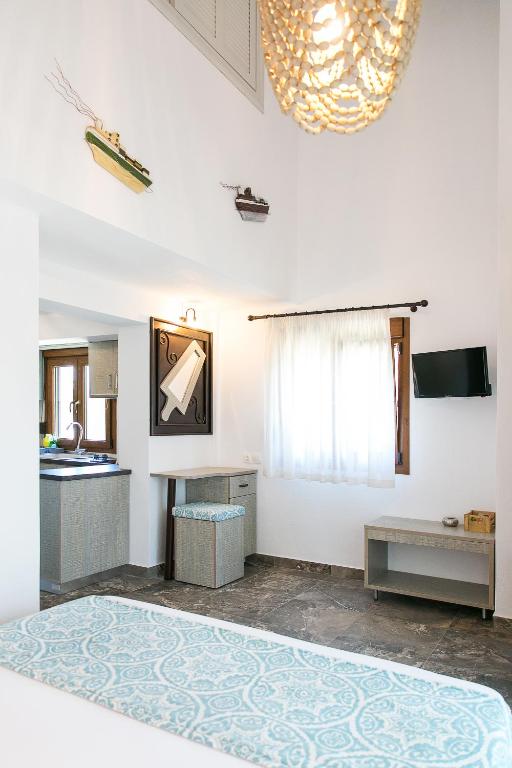 a white room with a table and a window at Alexandros Hotel Apartments in Vourvourou