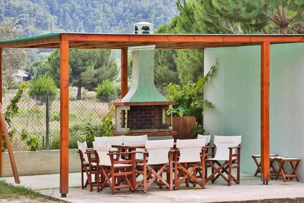 a group of chairs and a table and a fireplace at Alexandros Hotel Apartments in Vourvourou