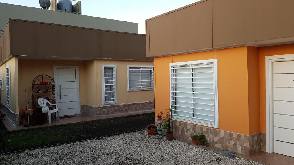 una casa naranja con dos puertas y un porche en Alfar Sol y Mar Casas en Mar del Plata